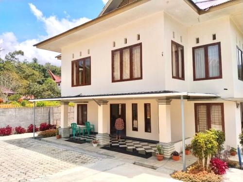 a white house with a courtyard in front of it at Homestay Possere in Sadang