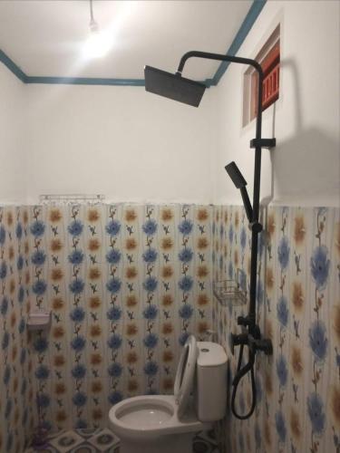 a bathroom with a toilet and a shower curtain at Surf Homestay Katiet surfing barrrels short motorcycle only minute from our places Bintang wave,Lance wave,HTs wave,monkeyWave in Katiet