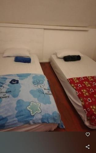 two beds sitting next to each other in a room at Surf Homestay Katiet surfing barrrels short motorcycle only minute from our places Bintang wave,Lance wave,HTs wave,monkeyWave in Katiet