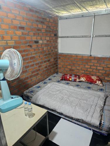 a room with a bed in a brick wall at Nomad Guesthouse by Buntha in Phumĭ Réach Born (2)