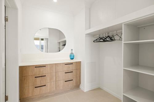 a bathroom with a wooden dresser and a mirror at Beach Lodges in Hamilton Island