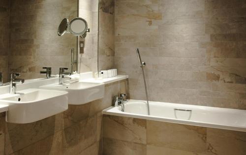 a bathroom with two sinks and a mirror at Trout Hotel in Cockermouth