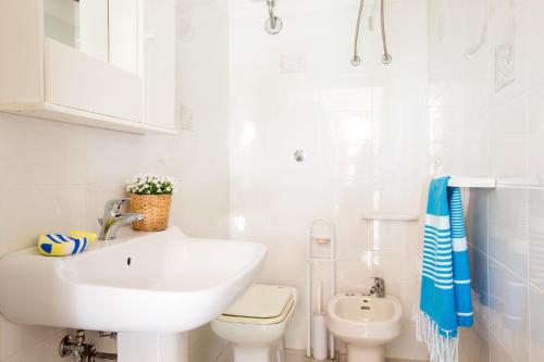 bagno bianco con lavandino e servizi igienici di Villa Anna a Torre Santa Sabina