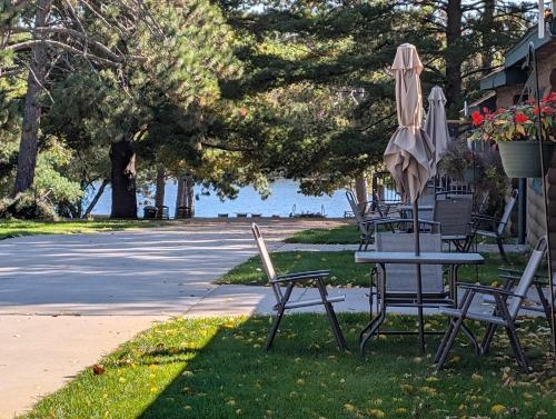 a table and chairs and an umbrella on the grass at Cozy Studio Cabin #5 Riverside Point Resort in Park Rapids