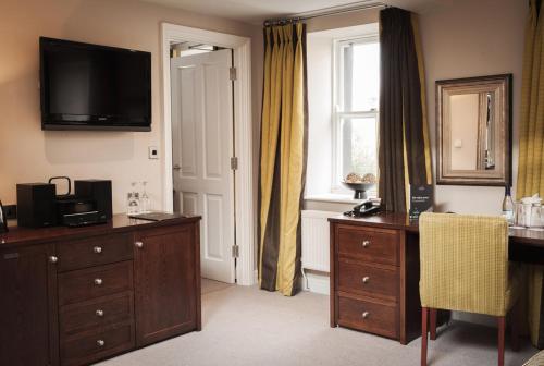 a room with a dresser and a television on the wall at Trout Hotel in Cockermouth