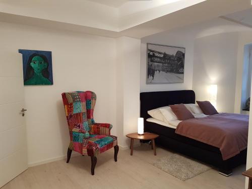 ein Schlafzimmer mit einem Bett und einem Stuhl in der Unterkunft Business Apartment Briller Viertel in Wuppertal