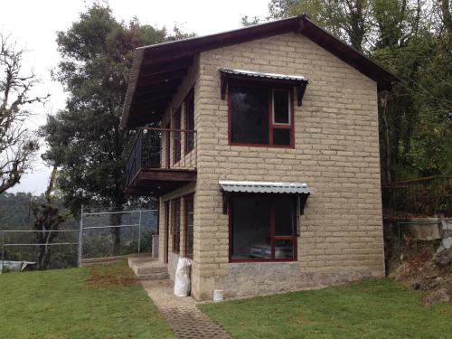 a brick house with a balcony on the side of it at Cabañas Hojarasca in Mineral del Chico