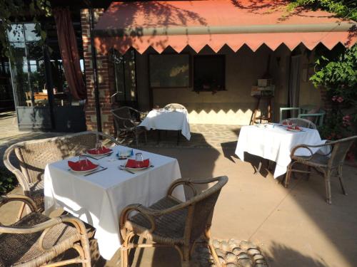 two tables with white table cloths on a patio at Cascina La Commenda in Peveragno