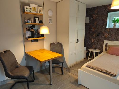 a bedroom with a desk and a bed and a table and chairs at Apartment Maiglöckchen in Fritzlar
