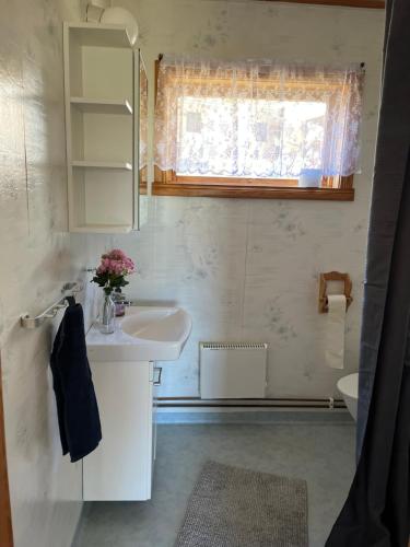 a white bathroom with a sink and a mirror at Sjönära stuga i flogned in Åmotsfors