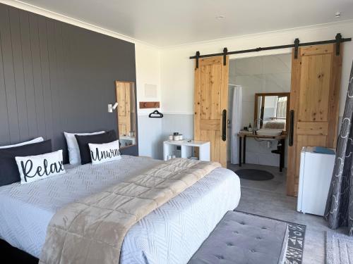 a bedroom with a large bed and a bathroom at Guesthouse on Ostler in Twizel