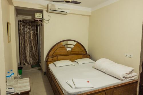 a bedroom with a bed with a wooden headboard at Aanand Hotel in Janakpur