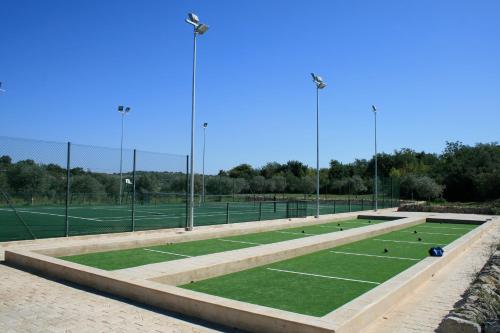 a tennis court with grass and tennis balls on it at Masseria Degli Ulivi - Noto in Noto