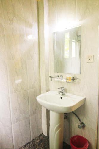 a white bathroom with a sink and a mirror at Center Park Resort Pvt.Ltd in Sauraha