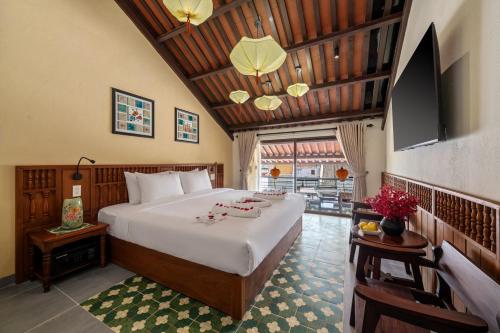a bedroom with a large bed and a tv at Solea Boutique Hoi An - Grand Opening April 2026 in Hoi An