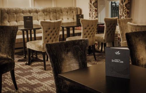 a group of tables and chairs in a room at Trout Hotel in Cockermouth
