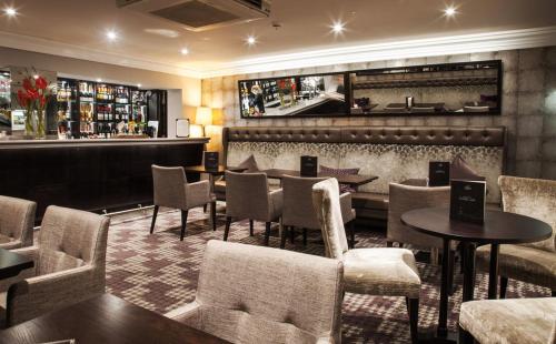 a restaurant with tables and chairs and a bar at Trout Hotel in Cockermouth