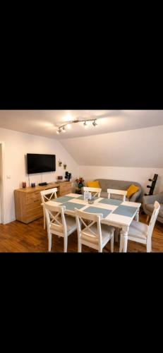 a dining room with a table and chairs and a tv at Ferienwohnung an der Dhron in Neumagen-Dhron