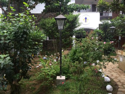 a garden with a lampost in the middle of a garden at Hotel & Restaurant Fleur de Lis in Concepción de Ataco