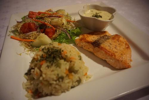 a plate of food with meat and potatoes and salad at Hotel & Restaurant Fleur de Lis in Concepción de Ataco