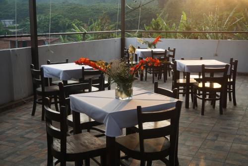 a group of tables and chairs with flowers on a balcony at Hotel & Restaurant Fleur de Lis in Concepción de Ataco