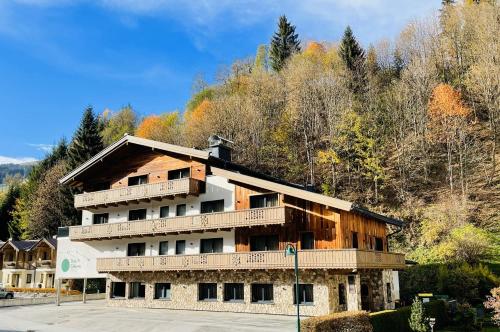 Ein Wohnhaus mit einem Berg im Hintergrund in der Unterkunft Das Glemm Hotel - Joker Card Partner in Saalbach-Hinterglemm
