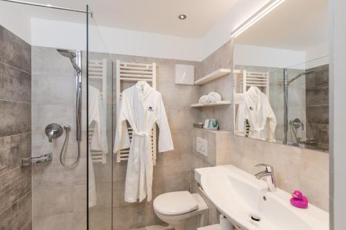 a bathroom with a shower and a toilet and a sink at ALPIN- Das Sporthotel - SKI IN SKI OUT cityXpress, SUMMERCARD INCLUDED in Zell am See