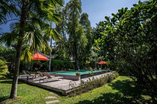 a swimming pool in a yard with palm trees at CocoCool Villas in Hinkong