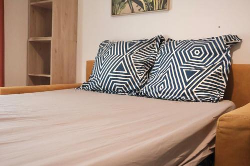 a bed with two pillows on top of it at Le Tiny Studio in Saint-Denis