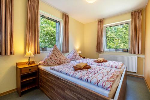 a bedroom with a bed and two windows at Gästezimmer - Meißen in Meißen