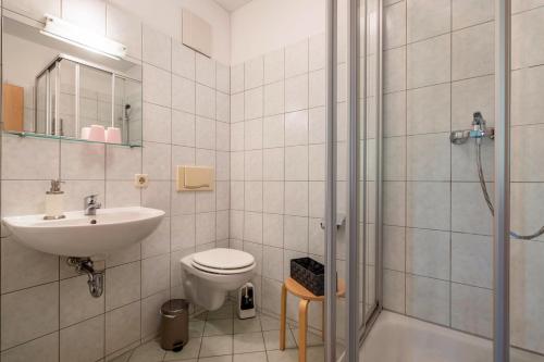 a bathroom with a toilet and a sink and a shower at Gästezimmer - Meißen in Meißen