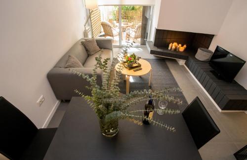 a living room with a couch and a table with a plant at Homz Studios Faliro in Athens