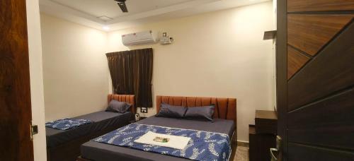 a small room with two beds and a window at PVR Grand Residency in Tiruvannāmalai