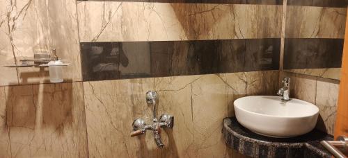 a bathroom with a white sink and a mirror at PVR Grand Residency in Tiruvannāmalai