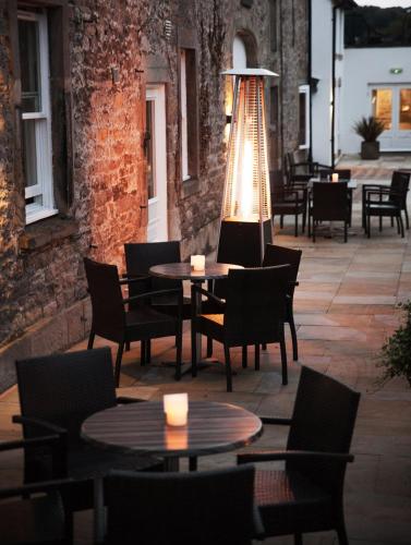 a patio with tables and chairs and a light at Trout Hotel in Cockermouth
