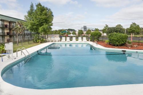 a swimming pool at a resort with blue water at Days Inn by Wyndham Valdosta/Near Valdosta Mall in Valdosta