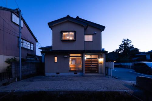 a house with lights in the window of it at Ninifuni Kanazawa in Kanazawa