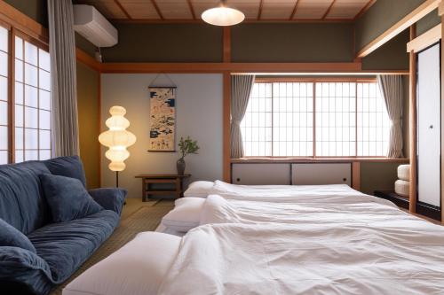 a bedroom with a large bed and a couch at Ninifuni Kanazawa in Kanazawa