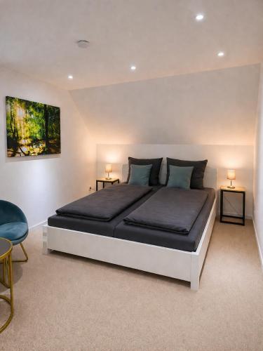 a bedroom with a large bed with two tables and two lamps at Ferienwohnung an der Dhron in Neumagen-Dhron