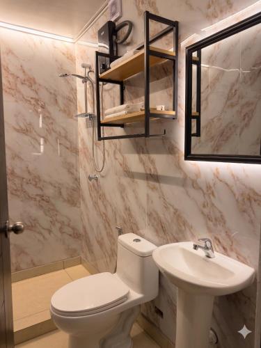 a bathroom with a white toilet and a sink at Ayni Living - Hostel in Lima