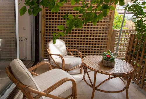 a patio with two chairs and a table on a porch at Homz Studios Faliro in Athens