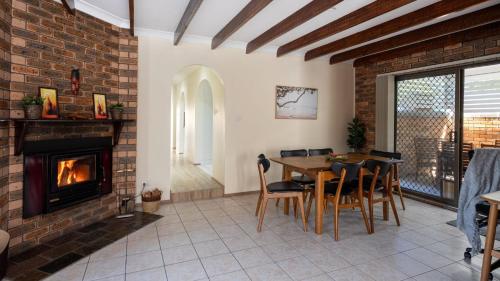a living room with a table and a fireplace at Coastal Crush in Callala Beach