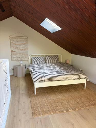 a bed in a room with a wooden ceiling at De groene salon in Broek in Waterland