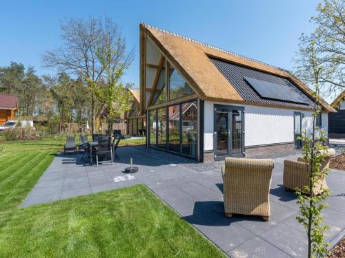 a patio with chairs and tables in a yard at Thatched luxury leisure farm for 6 people in Baarle-Nassau