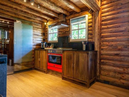 a kitchen with a red stove and wooden walls at Thatched luxury leisure farm for 6 people in Baarle-Nassau