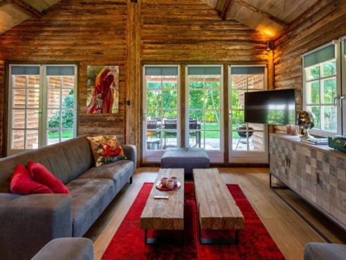 a living room with a couch and a tv at Thatched luxury leisure farm for 6 people in Baarle-Nassau