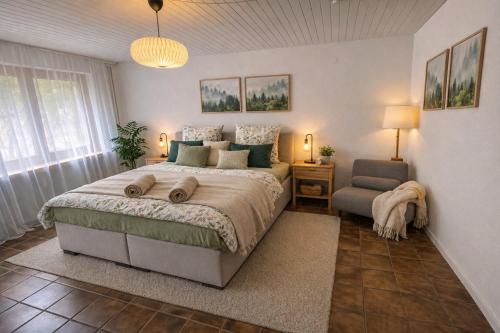 a bedroom with a large bed and a chair at Bollenhut 1 in Bad Wildbad