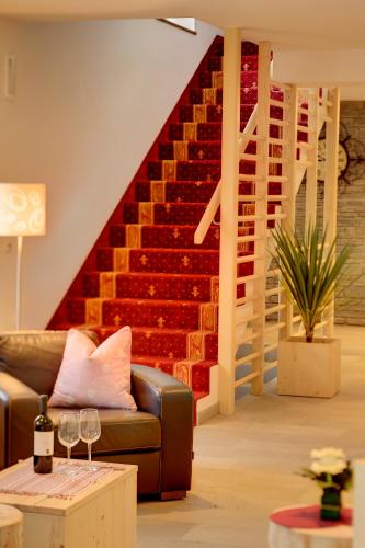 a living room with a couch and a staircase at Helmhotel in San Candido