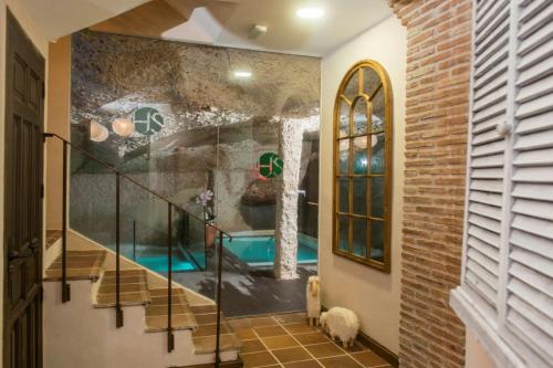 a home with a swimming pool in aoyer with a wall at Spa La Cueva del Agua in Hita