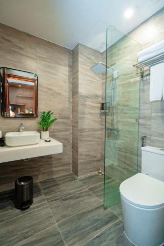 a bathroom with a toilet and a sink and a shower at Intechco Hotel S1-25 sầm Sơn in Sầm Sơn